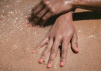 Self tanning lotion on hands at the beach